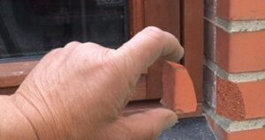 billede af en hånd der holder et stykke mursten